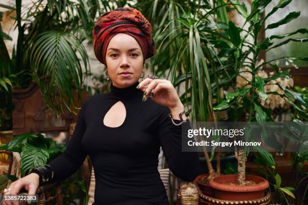 young fortune teller in turban among houseplants - cult stock pictures, royalty-free photos & images