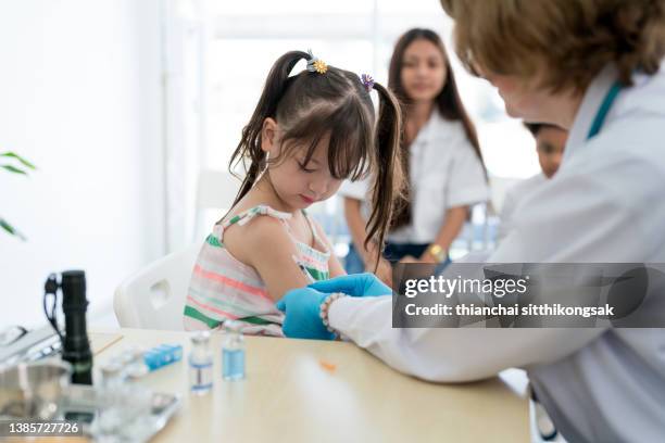 small group of elementary  student being vaccinated. - global health stock pictures, royalty-free photos & images