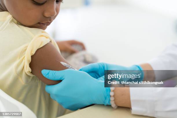 close up vaccination of a little boy on his arm in a doctor's office. - wereldwijde gezondheid stockfoto's en -beelden