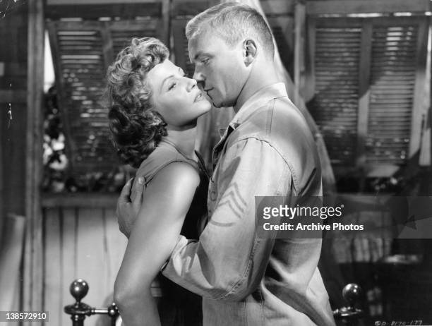 Rita Hayworth and Aldo Ray embrace on in a scene from 'Miss Sadie Thompson', directed by Curtis Bernhardt, 1953.