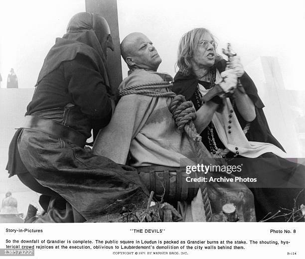 Michael Gothard next to actor Oliver Reed, who is about to be burned at the stake in a scene from the film 'The Devils', 1971.