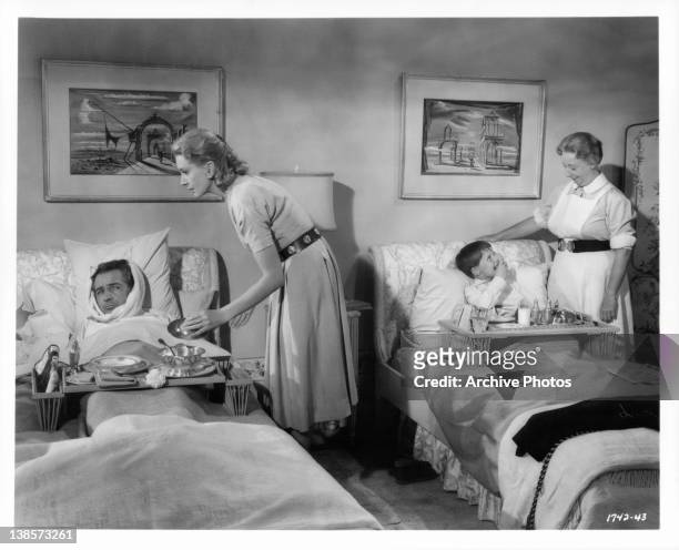 Deborah Kerr nurses Rossano Brazzi back to health from the measles as Mona Washbourne does the same with Martin Stephens in a scene from the film...