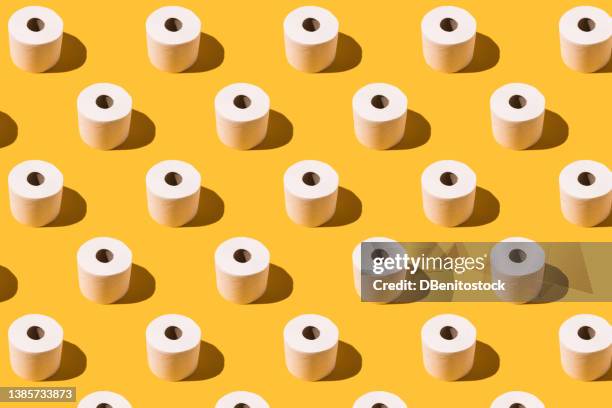 pattern of white toilet paper rolls on yellow background. concept of going to the bathroom, cleaning and pooping and peeing. - exkrement bildbanksfoton och bilder