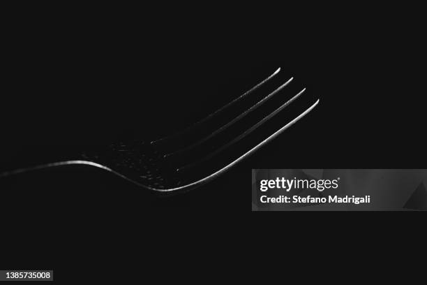 metal fork on black background - besteck freisteller stock-fotos und bilder