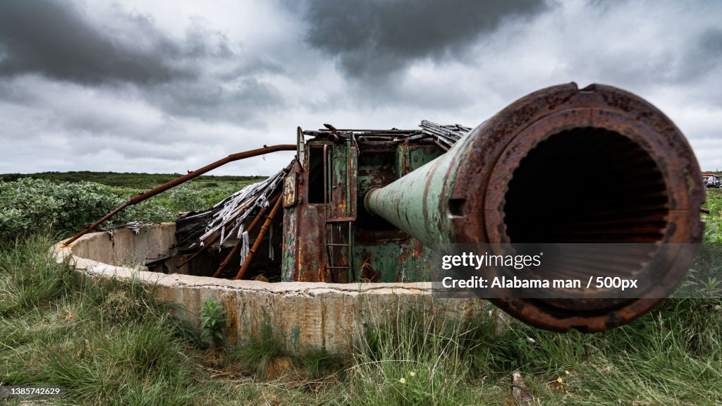 Coastal cannon,Close-up of rusty abandoned car against sky