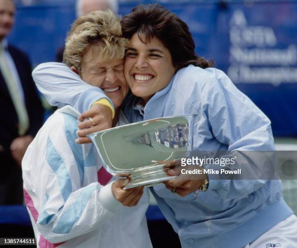 Doubles partners Robin White and Gigi Fernandez from the United States celebrate together holding the winning trophy after defeating Patty Fendick...