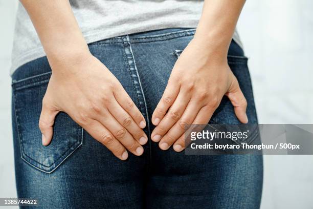 stomach ache,hemorrhoids,midsection of woman wearing jeans - woman hemorrhoids stock pictures, royalty-free photos & images