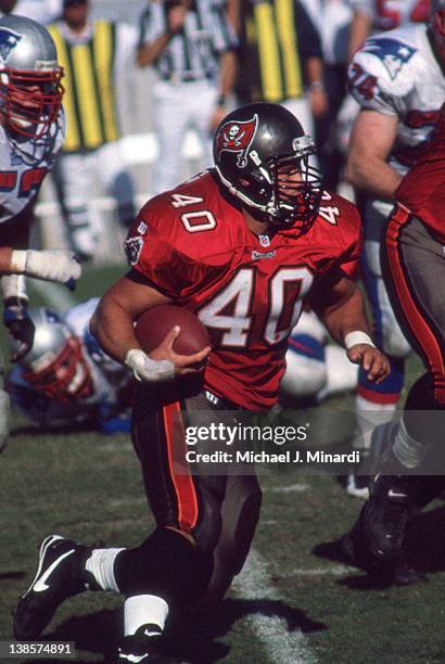 Fullback Mike Alstott of the Tampa Bay Buccaneers runs for some extra yardage in a NFL game against the New England Patriots at Tampa Stadium on...