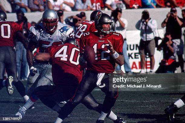 Quarterback Trent Dilfer of the Tampa Bay Buccaneers looks for a pass receiver while his teammate Fullback Mike Alstott blocks Linebacker Chris Slade...