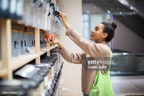 woman buying food in zero waste shop - reusable stock pictures, royalty-free photos & images