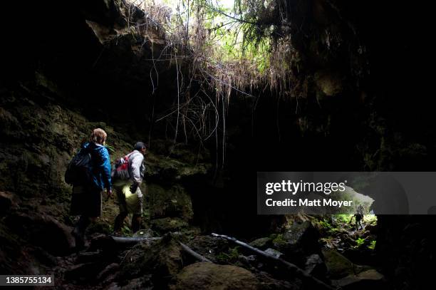 Tourists explore the inside of a lava tube on Santa Cruz Island in Galapagos National Park on January 19, 2012.