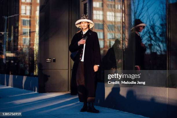 Ukrainian model Helga Hitko wears a black and white wide-brim floral hat, black jacket, black pants, black boots after the Peter Do show at Genesis...