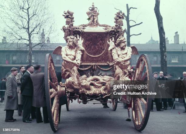 The Gold State Coach used for Queen Elizabeth II's coronation, 1953. The carriage built by Samuel Butler, dates from 1762 and the tritons on the...