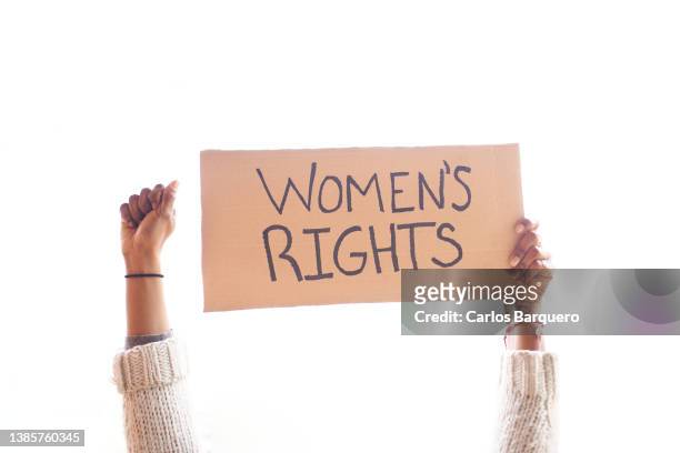 fist up and a placard protesting for women's rights. - female fist fights stockfoto's en -beelden