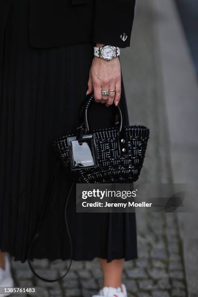 Palina Kozyrava is wearing aThierry Mugler black blazer, Prada black midi plisee skirt, Balenciaga black mini basket bag, white Zara crop top,...