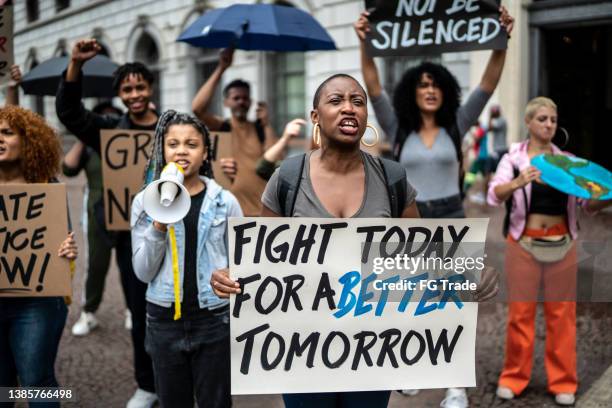 protests holding signs during on a demonstration - social justice concept stockfoto's en -beelden