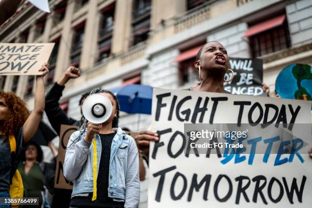 protests holding signs during on a demonstration - anti racism stock pictures, royalty-free photos & images
