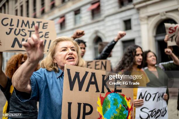 protests holding signs during on a demonstration for environmentalism - protest banner stock pictures, royalty-free photos & images