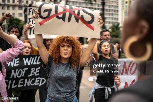 protests holding signs during on a demonstration for peace - protest against violence against women imagens e fotografias de stock