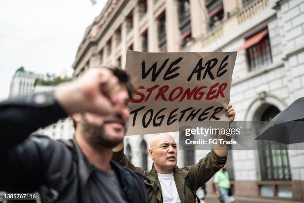 protests holding signs during on a demonstration outdoors - marching forward stock pictures, royalty-free photos & images