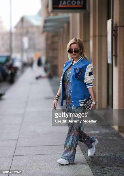 Palina Kozyrava is wearing a Missoni sparkling colorful jumpsuit, Louis Vuitton blue logo statement college jacket, Louis Vuitton graffiti statement...