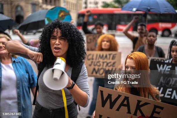 young woman leading a demonstration using a megaphone - anti graft stock pictures, royalty-free photos & images