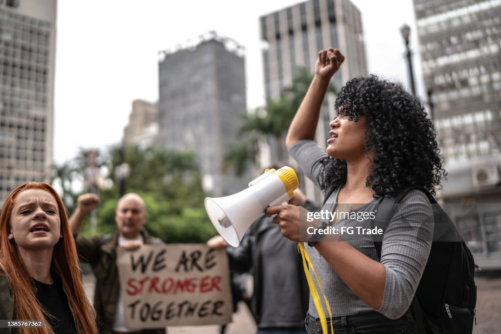 Young woman leading a demonstration using a megaphone
