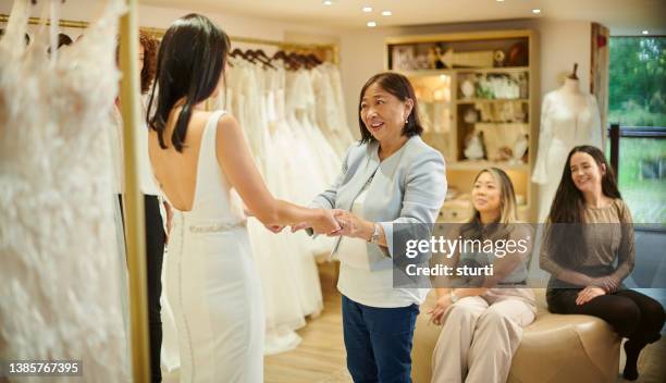 mother and daughter wedding dress shopping - bridal shop stockfoto's en -beelden