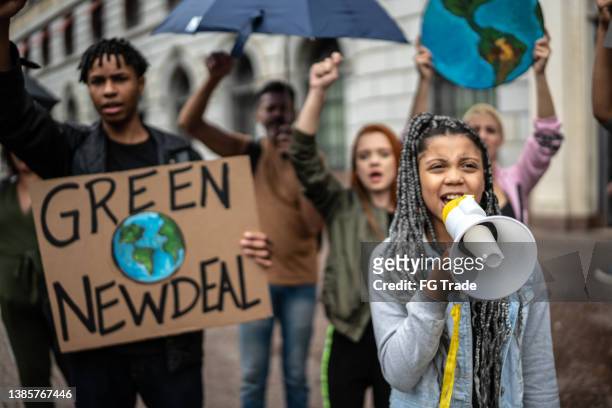 protests holding signs during on a demonstration for environmentalism - child marching stock pictures, royalty-free photos & images