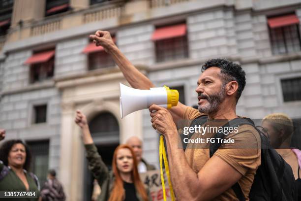 uomo maturo che conduce una dimostrazione usando un megafono - corruption foto e immagini stock