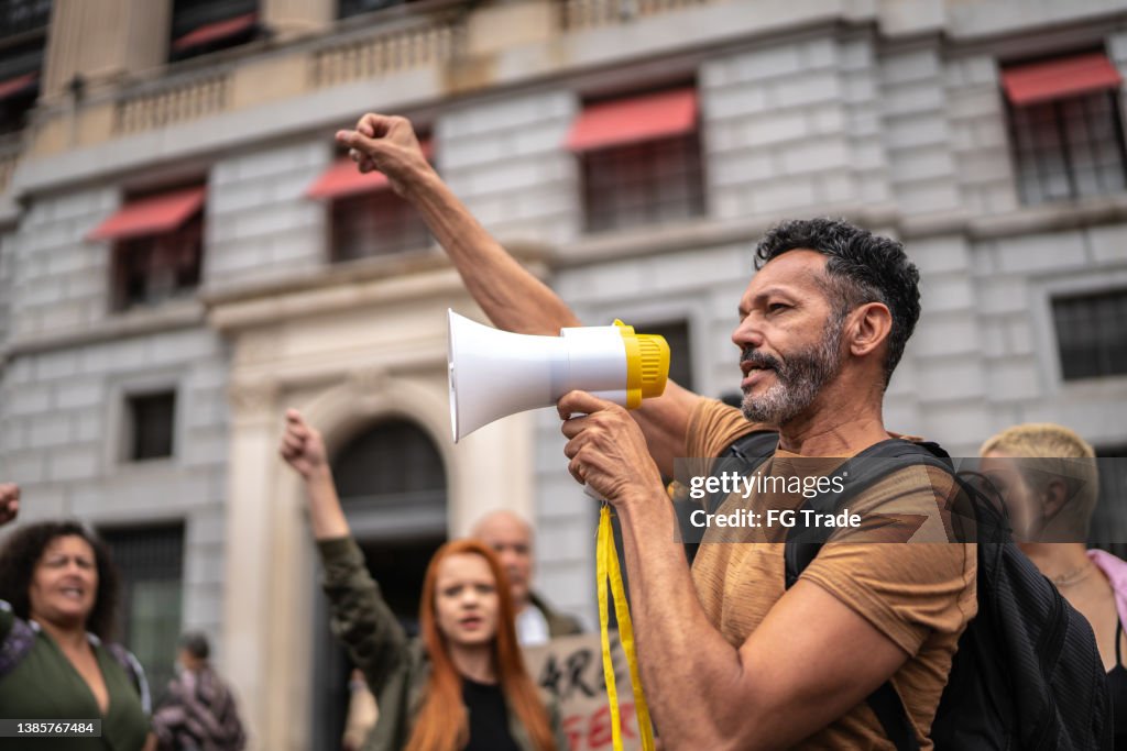 Mature man leading a demonstration using a megaphone