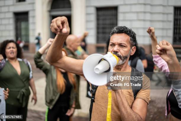 reifer mann, der eine demonstration mit einem megaphon leitet - anti corruption stock-fotos und bilder