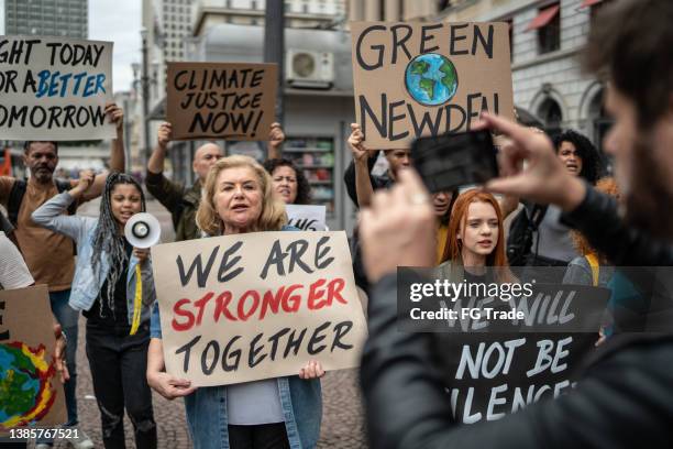 protests holding signs during on a demonstration for environmentalism - activists hold vigil marking 50th anniversary of march on the pentagon stockfoto's en -beelden