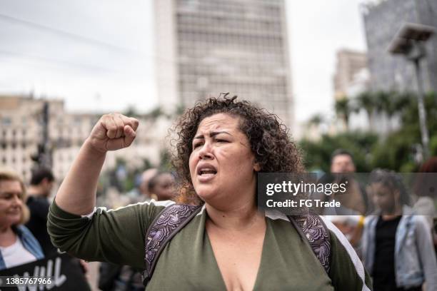 mid adult woman in a protest in the street - activists protests outside of trump tower in chicago stockfoto's en -beelden