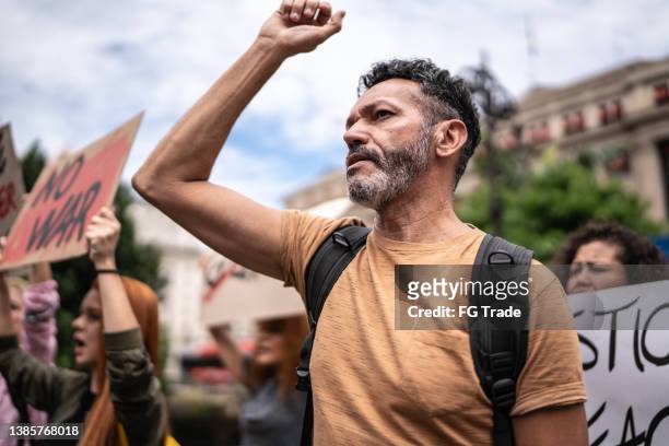 reifer mann während einer demonstration auf der straße - streetfight stock-fotos und bilder