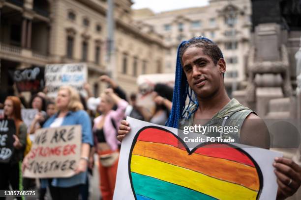 transgender woman holding a sign during a demonstration in the street - defend your rights stock pictures, royalty-free photos & images