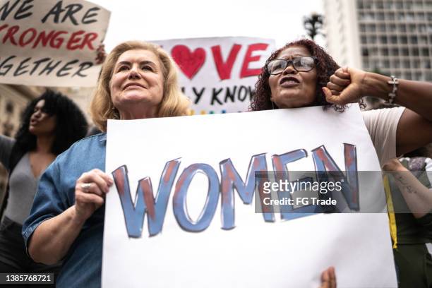 protesters holding signs during a demonstration in the street - marching stock pictures, royalty-free photos & images