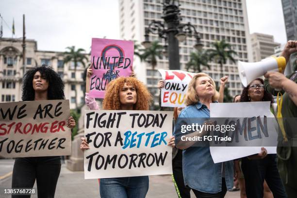protesters holding signs during a demonstration in the street - gender equality stock pictures, royalty-free photos & images