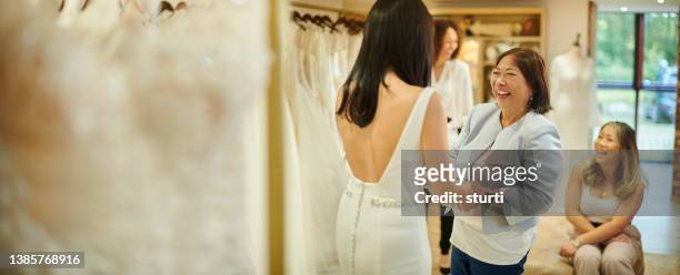 mother and daughter wedding dress shopping - wedding dress store stock pictures, royalty-free photos & images