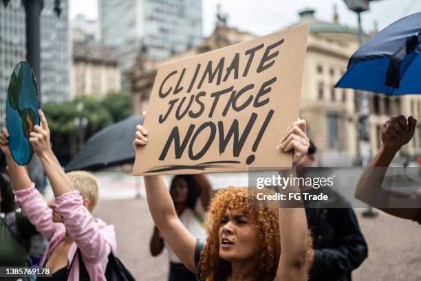 protesters holding signs during a demonstration in the street - anti globalization stock pictures, royalty-free photos & images