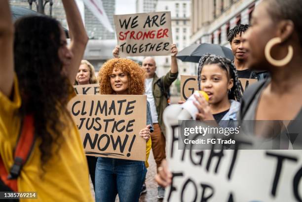 protesters holding signs during a demonstration in the street - climate change children stock pictures, royalty-free photos & images