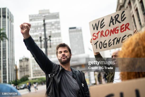 mature man during a demonstration in the street - male protestor stock pictures, royalty-free photos & images