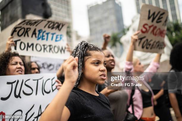 protesters holding signs during a demonstration in the street - anti racism children stock pictures, royalty-free photos & images