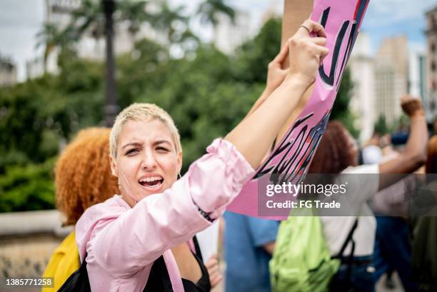 portrait of young woman on a demonstration for equal rights - marching stock pictures, royalty-free photos & images