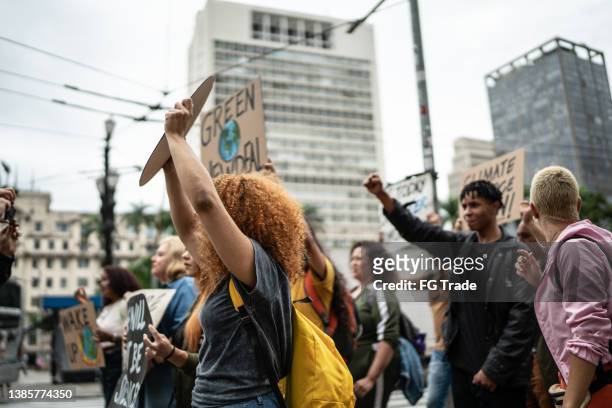 protesters holding signs during on a demonstration for environmentalism - climate protest stock pictures, royalty-free photos & images