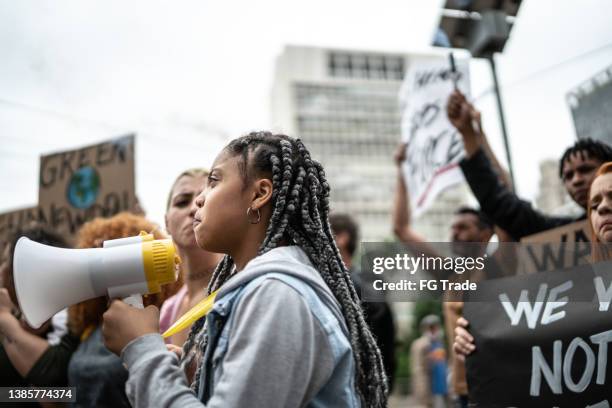 demonstranten während einer demonstration für umweltschutz - soziale gerechtigkeit stock-fotos und bilder