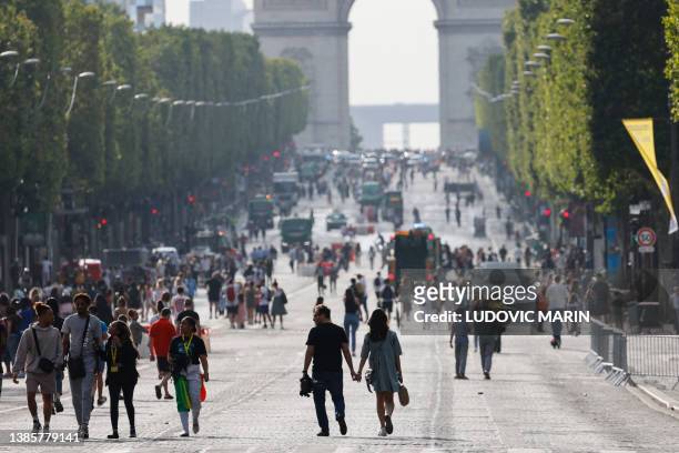 Pedestrians walk on Champs-Elysees avenue in Paris, on July 2 a day after protesters took to the street and clashed with police on an iconic street...