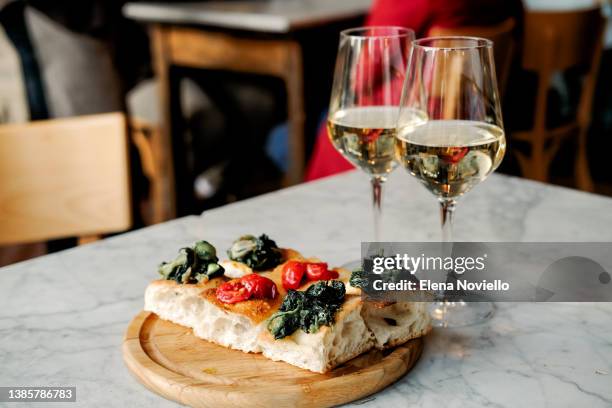 food italian style  bruschetta with tomatoes and glasses of white wine or prosecco on the table in the bar - prosecco stock-fotos und bilder