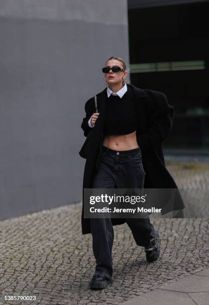 Alessa Winter seen wearing silver earrings, a white cropped button shirt blouse, a black oversized wool coat, a black cropped knit pullover, dark...