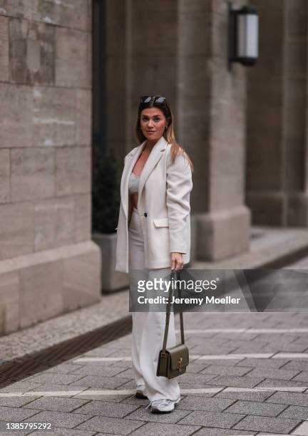 Nadine Klein seen wearing gold earrings, a black sunglasses, a creme white oversized blazer, a beige knit bralette, a creme white wide leg trousers,...